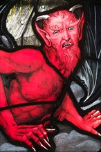 Portrait representing The Devil, in stained glass. Detail of a window in Saint Andrew’s Church in the Dorset village of West Stafford. England. UK.