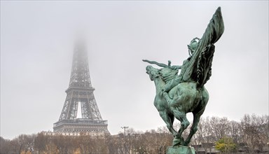 Eiffel Tower and Bir-hakeim statue on a misty day