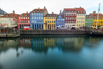 Long exposure of Denmark's iconic Nyhavn view in central Copenhagen with the colourful painted buildings with parked boats.