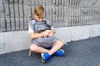 very sad boy bullying in school playground.