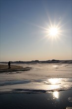 Man walking on melting ice sheet over Lake Michigan