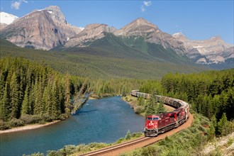 Train and railway with mountain scenery: A Canadian Pacific diesel locomotive transporting freight in Banff National Park.