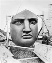 The bronze face of the Statue of Liberty uncrated awaiting installation in 1885 on Liberty Island, NY. The dark color is the result of oxidation of the copper material, which turned deeper brown, blac...