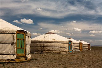 Four traditional tent homes of the nomads called gers with colorful doors lined up in a row in the Gobi desert in Mongolia
