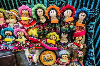 Colorful small cloth dolls for sale in a vendor's stall in the La Cancha market in Cochabamba, Bolivia.