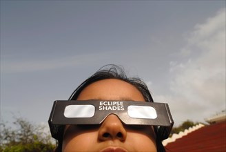 A young girl watches the partial solar eclipse by wearing a protected filter on 1st August 2008 in Bombay Mumbai
