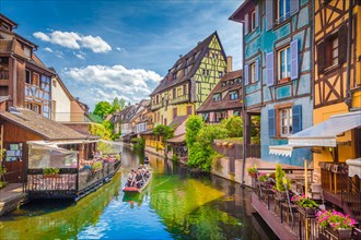 Beautiful view of the historic town of Colmar, also known as Little Venice, with tourists taking a boat ride along colorful houses, Alsace, France