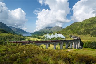 Vintage steam train passes the famous Glenfinnan viaduct with views over Loch Shiel