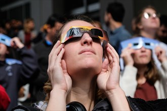 A woman watches the solar eclipse in the city centre of San Francisco, USA.