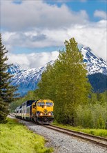 Snow capped mountains in background of Alaska Railroad’s Coastal Classic train from Anchorage to seward Alaska