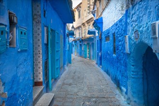 Beautiful view of the blue city in the medina. Traditional moroccan architectural details and painted houses in CHEFCHAOUEN, MOROCCO. street with door