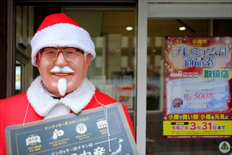 OTARU, JAPAN - NOVEMBER 12, 2019: Colonel Harland Sanders Figure in Santa Claus costume standing in front of Kentucky Fried Chicken restaurant in Otar