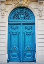 Old fashioned front door entrance, white facade and blue door, Paris, France