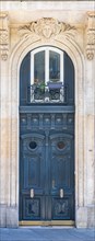 Paris, an ancient wooden door, typical building in the 11e arrondissement