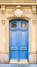 Paris, a blue wooden door, typical building in the center