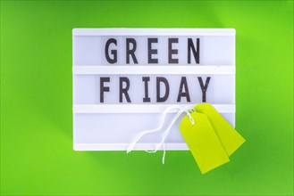Green Friday concept with green sale and discounts tag, conscious and environmentally friendly shopping idea, useful things on sale instead of the usu