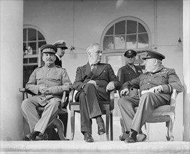 Joseph Stalin, Franklin D. Roosevelt and Winston Churchill on the veranda of the Soviet Legation in Teheran, during the first “Big Three” Conference, November 1943. In the background are aides to the ...