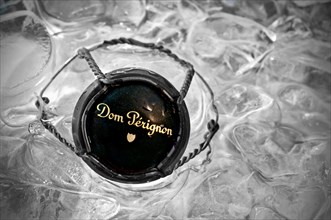 'Dom Perignon' vintage champagne close-up on wire retaining frame and metal top cap in ice bucket (B&W/Colour)