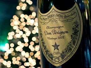 Bottle of 2002 Dom Perignon luxury vintage champagne with sparkling lights in background