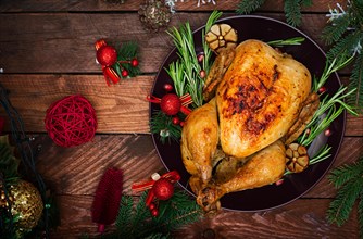 Baked turkey or chicken. The Christmas table is served with a turkey, decorated with bright tinsel and candles. Fried chicken, table. Christmas dinner