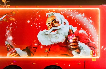 Coca-Cola Christmas truck side in the UK depicting traditional Santa Claus or Father Christmas holding a bottle of Coke