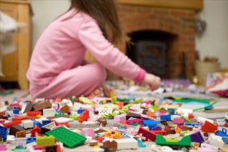 Child sat on floor playing with lego