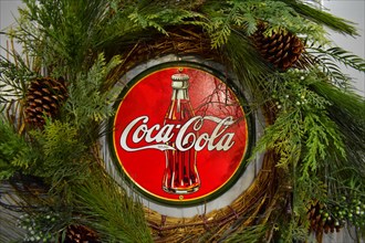 Orlando, Florida; November 24, 2018. Vintage Coca Cola poster with Christmas decorations in International Drive area.