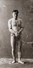 Magician and illusionist Harry Houdini in chains and handcuffs