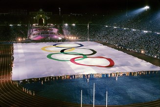 Barcelona, Spain, 1992: Hundreds of people hold edges of huge Olympic flag on the field at Montjuic Stadium during opening ceremonies of the Olympic Summer Games.   ©Bob Daemmrich