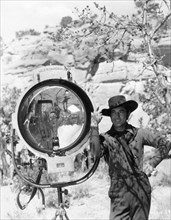JOHNNY MACK BROWN publicity pose on set location candid next to Mole-Richardson movie light during location filming of  BILLY THE KID 1930 director KING VIDOR book Walter Noble Burns dialogue Laurence...