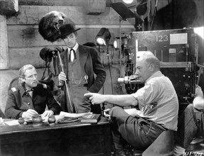 JOHN MILJAN as General George Armstrong Custer GARY COOPER as Wild Bill Hickok and Direcor CECIL B. DeMILLE on set candid during filming of THE PLAINSMAN 1936 director CECIL B. DeMILLE Paramount Pictu...