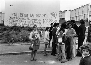 After the socialist military coup, the so-called Carnation Revolution in Portuga. On the wall behind the occupiers someone has written “At the forefront of the fight for bread, we form committees of M...