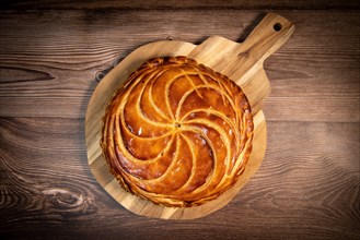 Galette des rois on wooden table, Traditional Epiphany cake in France