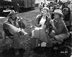 JAMES STEWART ELAINE STEWART and Director JAMES NEILSON with Movie Crew on set location candid in the Colorado Rockies during filming of NIGHT PASSAGE 1957 story Norman A. Fox screenplay Borden Chase ...