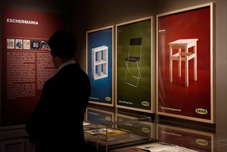 A visitor looks on artworks by Dutch engraver and graphic designer Maurits Cornelis Escher on display at the 'Escher' exhibition