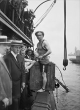 Escapologist Harry Houdini (1874 - 1926) preparing to perform his famous "overboard box escape" for the first time in July 1912.