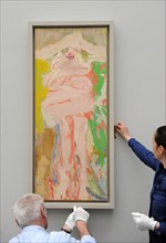 Museum employees hang the picture 'Woman with Hat' by Willem de Kooning for the upcoming exhibition 'Women' at the Pinakothek der Moderne in Munich, Germany, 22 March 2012. The exhibition with picture...