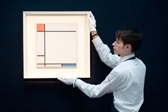 London,UK - 14 June 2013: A Sotheby's employee holds a work by Piet Mondrian entitled “Composition with red, Yellow amd Blue, 1927) (Est. £4.5-6.5 million) during the preview of this summer auction at...