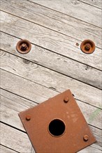 Faces in places. Face in objects. Pareidolia. Actually a wooden cable reel with bolts and central metal hub.