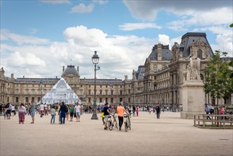 Paris, France - 06/25/2016: tourists visiting the Louvre, Pyramid covered in ephemeral artwork by JR "unframed" project