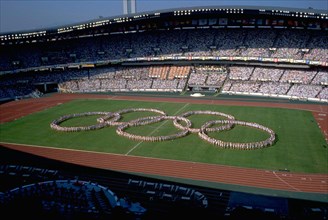 Seoul, Korea, 1988: Performers form the interlocking Olympic rings before a packed stadium audience during the opening ceremonies at the summer Olympic Games. ©Bob Daemmrich