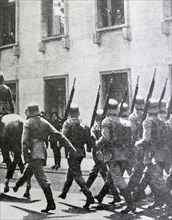 Black and white photo of soldiers marching down a street in Berlin, on the morning after the Night of the Long Knives (30 June 1934).