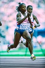 Gail Devers (USA) #1687 and Evelyn Ashford (USA) competing in the semi-finals of the Women's 100 meters at the 1992 Olympic Summer Games.