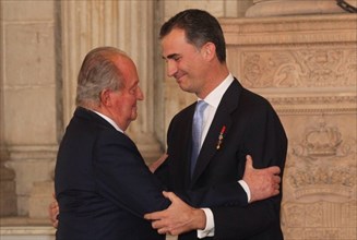 The King Juan Carlos I de Borbon (L) of Spain embraces his son Felipe de Borbon after signing the law on his abdication at the Royal Palace of Madrid in Madrid, June 18, 2014. The King signed on Wedne...
