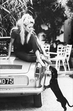 Black & White photography print with an iconic photo of Brigitte Bardot with Dachshund at her villa in St. Tropez, France. 8th October 1962.