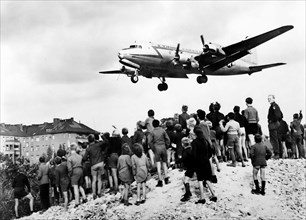 Berlin Airlift. West Berliners watch a Douglas C-54 Skymaster land at Tempelhof Airport in 1948, during the Berlin Blockade (24 June 1948 – 12 May 1949)