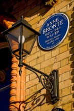 Close up of blue plaque to writer Anne Bronte and ornate lantern lamp on wall of The Grand Hotel Scarborough North Yorkshire England UK Great Britain