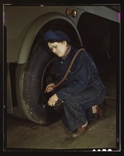 War production workers at the Heil Company making gasoline trailer tanks for the U.S. Army Air Corps., Milwaukee, Wisconsin. Mrs. Angeline Kwint, age 45, an ex-housewife, checking the tires of trailer...