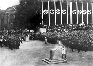 A German athlete lighting the torch at the opening ceremony for the 1936 Berlin Olympics.