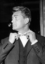 Actor Jean Marais fixing his bowtie